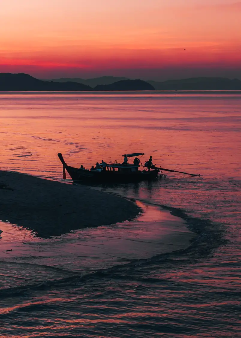 Peaceful sunset with a traditional Thai longtail boat at Phang Nga Bay