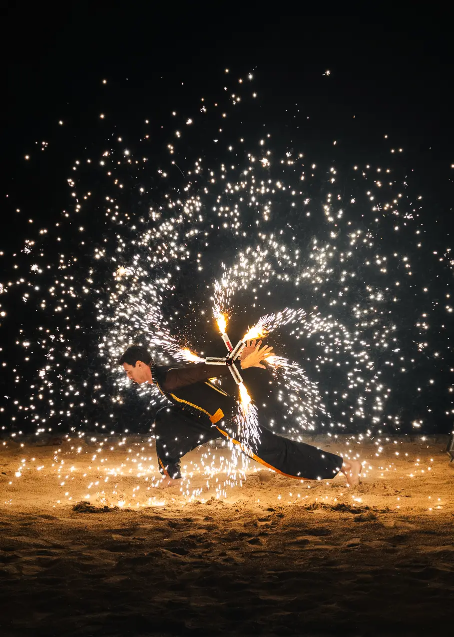 Thai fire show on the beach, offering cultural experience at ÀNI luxury resort in Thailand